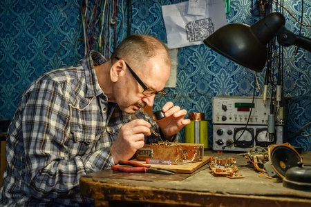 Photo in retro style with elderly man repairing an old radio receiver at home