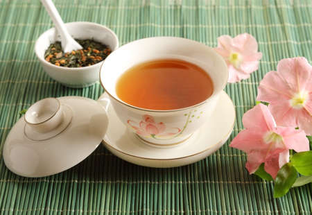 A cup of tea with flowers on the tableの写真素材
