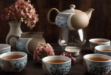 Studio photo of a tea set with tea poured into cupsの写真素材