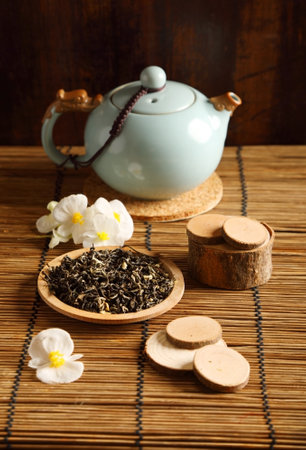 Studio shot of a tea pot with flowers on the tableの写真素材