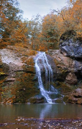 Beautiful waterfall with a pond in the autumn mountains in Adygea Republic, Russiaの写真素材