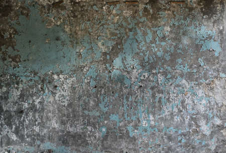 The texture of an old wall with peeling paint of an old abandoned industrial building, close-upの写真素材