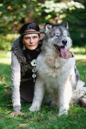 Portrait of a forest dweller woman with a big Alaskan Malamute dog outdoorsの写真素材