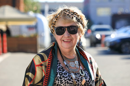 Portrait of a stylishly dressed grandmother on the street on an autumn sunny day