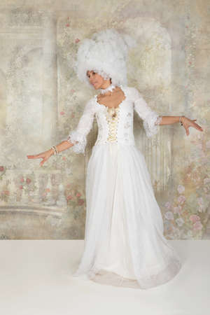 Lady dressed in wigs and baroque style clothes posing in the studioの写真素材