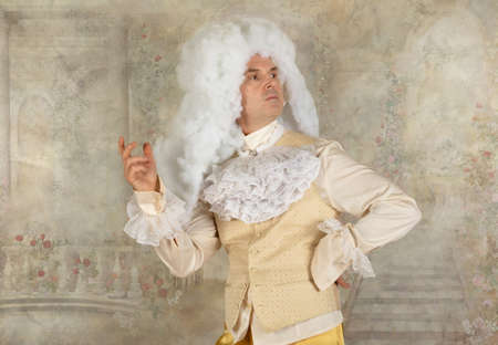 Man dressed in wigs and baroque style clothes posing in the studioの写真素材