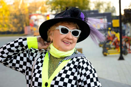 Portrait of a senior woman in black hat and sunglasses outdoorsの写真素材