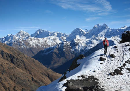 Tourist girl walks along a snow-covered mountain side in the Elbrus region, Russiaの写真素材