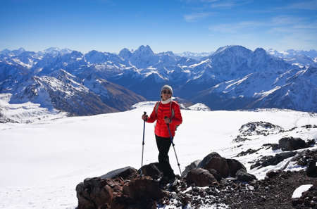 Female tourist posing on the background of Elbrus mountains in Russiaの写真素材