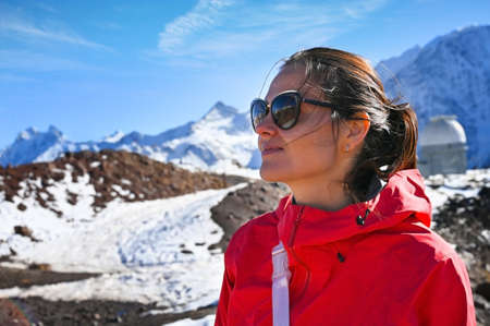 Portrait of a tourist girl posing on the background of Elbrus mountains in Russiaの写真素材