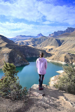 Travel destination concept with young adult female tourist enjoying a mountain view in the Elbrus mountains in Russiaの写真素材