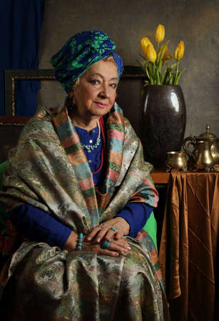 Portrait of an elderly woman with flowers in the studioの写真素材