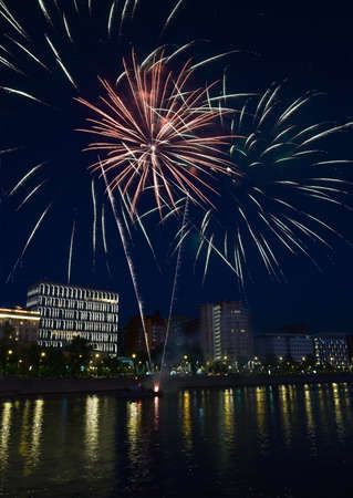 Evening colorful fireworks near waterの写真素材