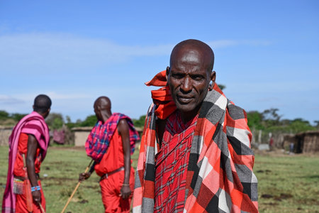 MAASAI MARA NATIONAL RESERVE, KENYA, AFRICA - NOVEMBER 11, 2022: People of Kenya. Portrait of a maasai man against the blue sky in maasai village in Kenya, Africaのeditorial素材