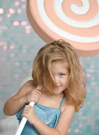 Portrait of a cute little girl with a toy candy lollipop in the studioの写真素材