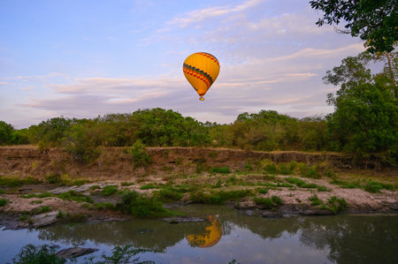 Hot air balloon is flying in the blue sky over the African savannah. Kenya.の写真素材