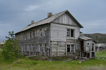 Traditional northern ruined wooden houses on the shores of the Barents Sea. Teriberka, Murmansk region, Russiaの写真素材