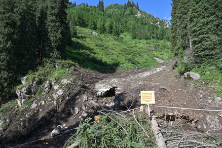 The glacier descended in the valley of the Nizhny Butakovsky waterfall. The warning sign says: "The passage is temporarily prohibited! A mudflow-prone area". Tien Shan Mountains in Kazakhstanの写真素材