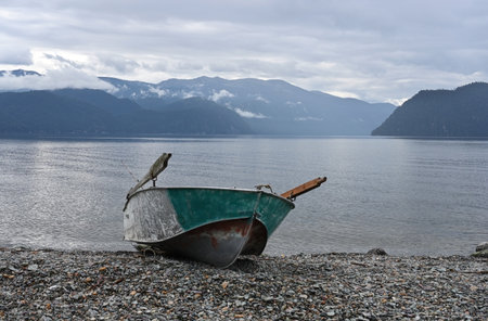 Delightful landscape with a rowing boat on the shore of a mountain lakeの写真素材