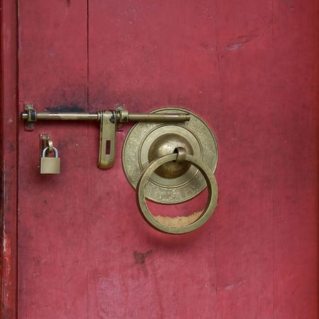 Door lock from golden metal on red backgroundの写真素材