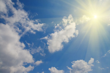 The sun in the clouds in a blue sky. Can be used as a background.