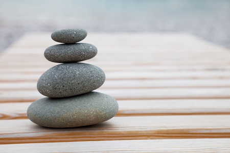 The pyramid of pebbles on a wooden backgroundの写真素材