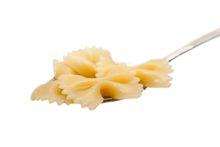 Pasta Bows on the spoon. Isolated on a white background