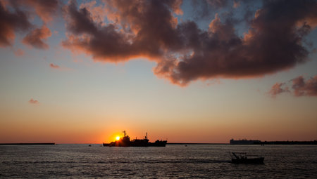 The ship floating on the sea at sunset 
