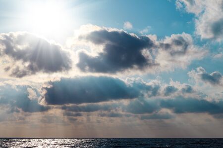 The rays of the sun breaking through clouds over the seaの写真素材