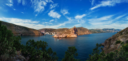 Seacoast. Sea mountains under the blue sky with clouds 
