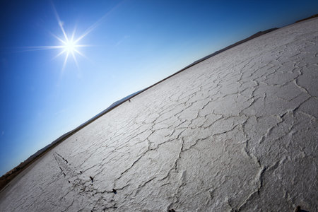Dry lake under a blue sky and a bright sun