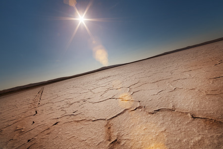 Dry lake under a blue sky and a bright sunの写真素材