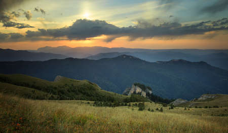 Landscape. Mountain ridges at sunset against the sky with cloudsの写真素材