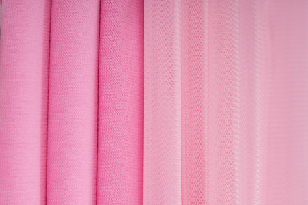 Pink knitted fabric laid in waves. Can be used as a backgroundの写真素材
