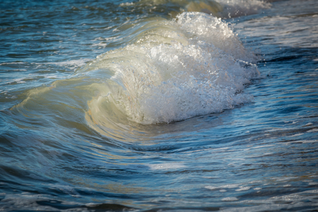Foamy wave rushes to shoreの写真素材