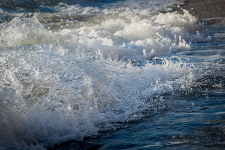 Foamy wave rushes to shoreの写真素材