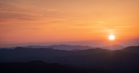 Colorful sunset over the mountain hillsの写真素材