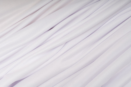 Background of white cloth with pink hue in the foldsの写真素材