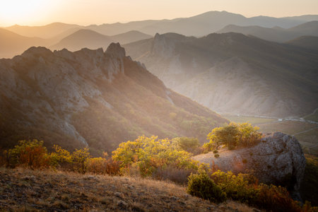 Mountains and forest in the rays of the sun at sunsetの写真素材