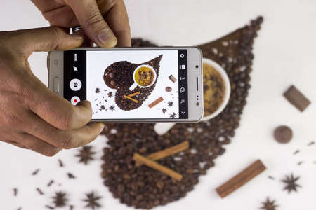 Taking a picture of coffee with mobile phoneの写真素材