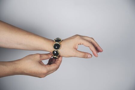 young woman hand black bracelet on gray backgroundの写真素材