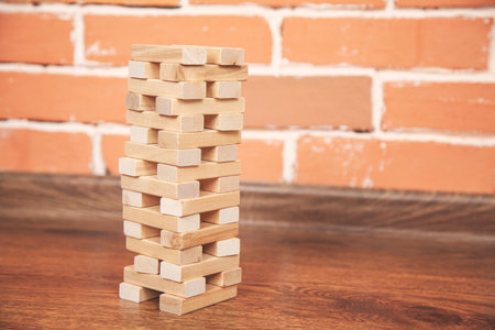 wooden Architectural cubes on table on brick wall background
