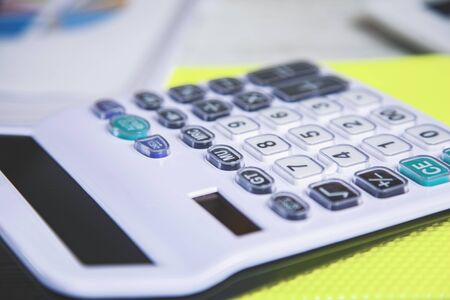 white calculator on notepad on the deskの写真素材