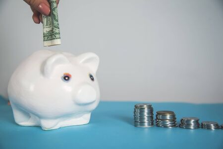 woman hand money on piggy bank  on deskの写真素材