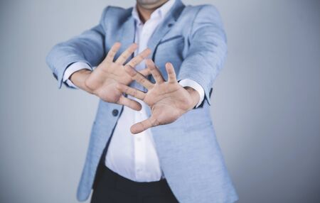 man hand stop sign on gray wall backgroundの写真素材