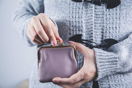 woman hand holding wallet on gray backgroundの写真素材
