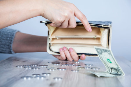 woman hand wallet with coins on the desk