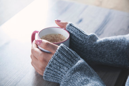 woman hand cup of coffee on the desk