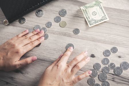 woman hand coins with wallet on deskの写真素材