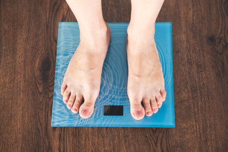 woman foot in scales on the wooden background